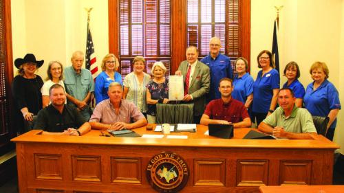 Left to right – Back: Jennifer Lane, Marilyn Cernoch, Billy Teague, Kathleen Kramr, Carolyn Heinsohn, Betty Danner, Judger Dan Mueller, John Bartos, Marilyn Kothmann, Cathleen Noska, Phyllis Teykl, Carolyn Surface; Front: Commissioners Drew Brossmann, Harvey Berckenhoff, Clint Sternadel and Jason McBroom. Photo by Jeff Wick