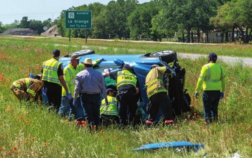 La Grange firefighters and Fayette County EMS personnel work to get inside a car that crashed on SH 71 Monday. The driver died at the scene. Photo by Andy Behlen