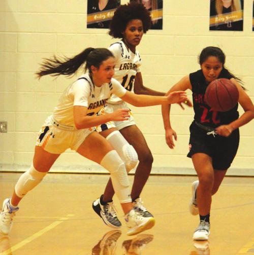 La Grange’s Keslyn Davis, foreground, and Aysia Grant, background, work together to force a turnover in Tuesday’s season opener against Gonzales. Photo by Jeff Wick