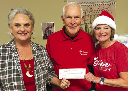 Eric Batchelder of the St. James Men’s Club, presents Debra Blansitt (left), President of the Schulenburg Food Pantry and Pantry volunteer Judy Janik with a $1,000 Christmas donation from St. James.