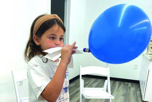Students participate in a balloon rocket balloon experiment (above), and a flight simulation game (below).