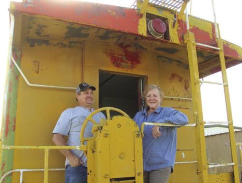 Gary Gillentine, left, and Carlie Brewer, right, stand on the back of the caboose Brewer recently bought to turn into a tiny home. Gillentine is aiding his expertise to the project. Photos by Jeff Wick