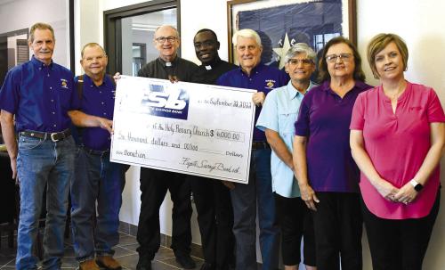The Weimar KCs and Catholic Daughters recently donated $6,000 to the Hostyn church rebuilding fund. Pictured are (from left) Delphin Bartek - KC Grand Knight, Frank Janacek - KC Treasurer, Fr. Wayne Flagg - Weimar and Dubina churches, Rev. Felix Twumasi-Hostyn Church pastor, Jack Muggli - KC District Deputy, Martha Janecka - CDA Chairperson of fundraiser, Mary Jane Berger - CDA Regent, and Jennifer Moring, Asst. VP, Lobby Manager, Fayette Savings Bank in Weimar. Photo courtesy of Weimar Mercury