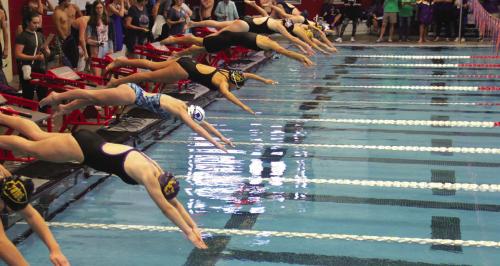 La Grange’s Hope Michalke and her competitors jump into the pool at the start of an event in Grapevine.