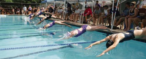 Swimmers dive into the water at the beginning of their first home meet Saturday at Camp Lone Star. Photo by Brittany Dawson