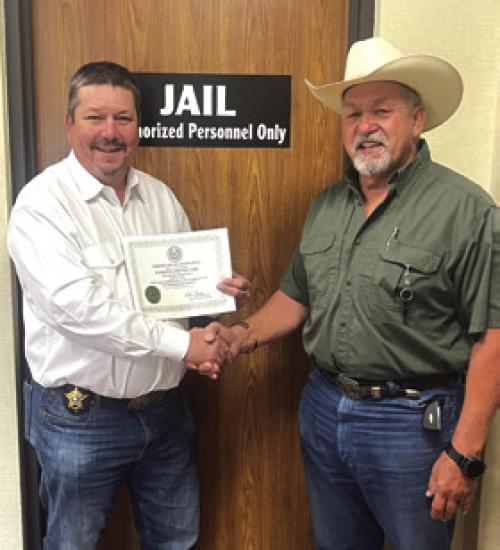 Brad Neville, left, new Jail Administrator, shakes hands with Sheriff Keith Korenek, as they show off their inspection certificate.