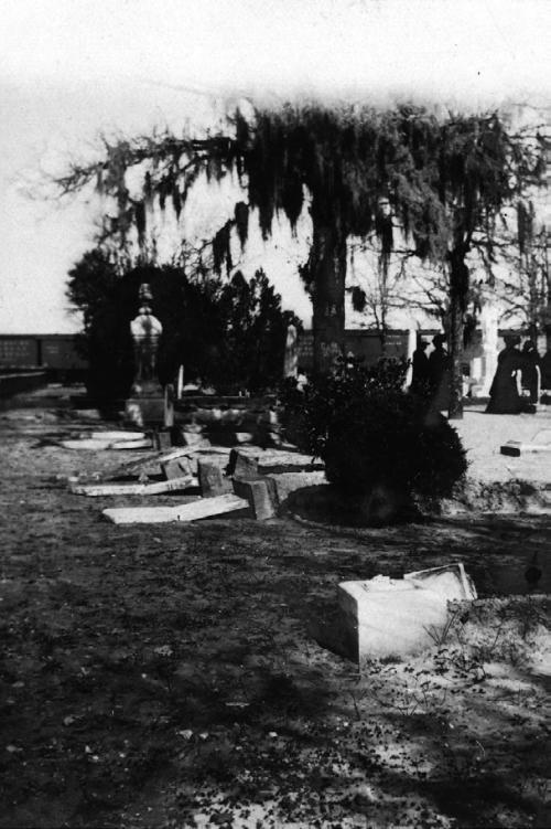 February 1908 photograph showing the broken tombstones along North College Street after vandalism in the old La Grange City Cemetery done by a drunken and disgruntled railroad worker. Train cars and onlookers can be seen in the background. Some of this damage is still evident today. Photo courtesy of the Fayette Heritage Museum and Archives