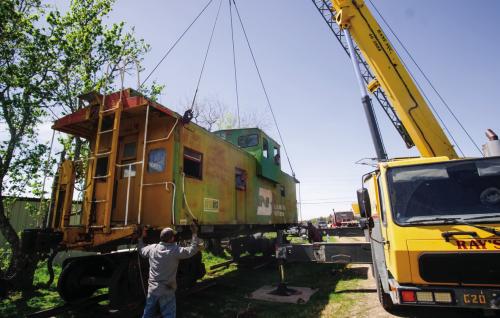 Charlie Brewer and Gary Gillentine peek out of the windows of this 1957 Burlington Northern Caboose as Ray’s Crane Service moves the caboose into place on wheels at Brewer’s home in La Grange near the intersection of Von Minden Road and Highway 71 on Wednesday. Brewer recently purchased the caboose and, with the help of Gillentine and Lee Kimbrell, is fixing it up as a tiny home to sell. More on the project in an upcoming edition of The Record. Photo by Andy Behlen