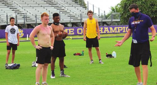 A masked David Cooper, right, (who was just promoted to assistant head coach this summer) instructs some La Grange athletes about footwork Tuesday morning. Photos by Jeff Wick