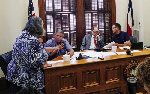 Commissioners and County Judge Dan Mueller review projected salary expenses with County Auditor Cindy Havelka (left) at last Thursday’s Commissioners Court meeting. Photo by Andy Behlen