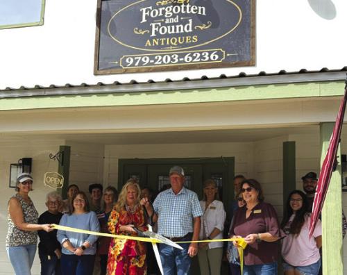 Aribbon cutting for the new antique shop in Carmine, Forgotten and Found Antiques was held Oct. 3 hosted by the Carmine Chamber of Commerce. Pictured are owners Christine and Stephen Rosenbaum (center.) Diane Tovey and Marlene Waak are holding the ribbon. Other members of the Carmine Chamber of Commerce are pictured in the background.