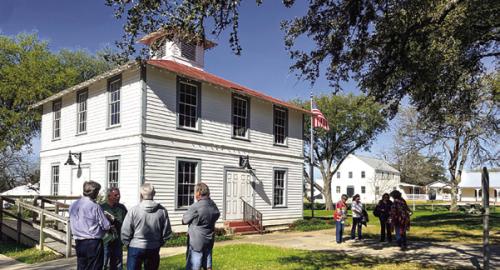 Attendees stand outside the Round Top Precinct Courthouse before a recent meeting. Record file photo
