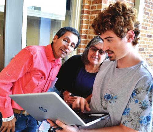 Nicolas England explains the ins and outs of Linux to new computer owners Maria and Juan Guajardo. Photos courtesy of Bill Bishop