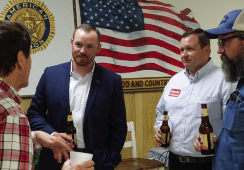Post-town hall beers in hand, Fayette County Judge run-off candidates Josh Homan, second from left, and Josh Vandever, third from left, chat with attendees after Tuesday’s event. Photo by Andy Behlen