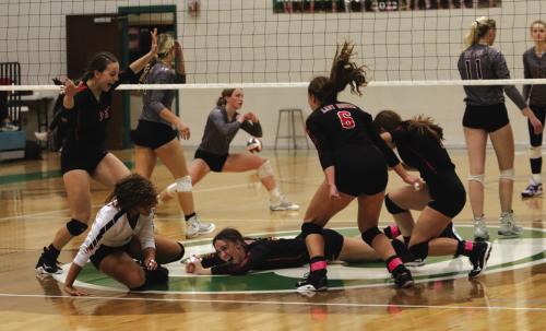 Schulenburg’s Meredith Magliolo, center, lays on the ground as her teammates circle around her after she hit the final point to clinch the regional championship over Johnson City Saturday, sending the Lady Horns to the state volleyball tournament. Photo by Audrey Kristynik