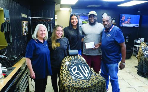 The local nonprofit Fayette County Helpers presented a plaque of appreciation to the Brian Williams Barbershop for providing more than 100 free haircuts to students heading back to school this year. Pictured are (from left) Karen Forest of Fayette County Helpers; Jayde Manasco, Citlalli Barcenas and Brian Williams of Brian Williams’ Barbershop; and Jeff Kelly of Fayette County Helpers. Photo by Andy Behlen
