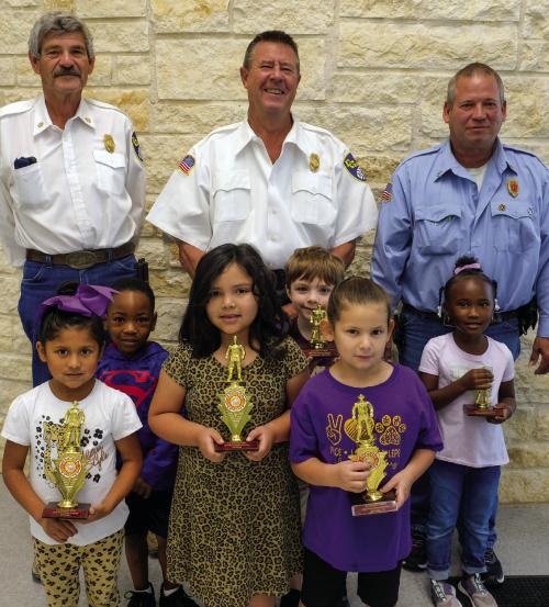 Winners of the fire poster contest for Pre-K and Kindergarten at La Grange Elementary went to (front, from left) Ruthie Lemus, Consuelo Balderas and Malaya Castaneda. Honorable mention winners were (middle row) Ayden Davis Nathan Wayne Lincke and Amiyah Grant. Pictured with them are (back, from left) Asst. Chief Frankie Srubar, Fire Chief Frank Menefee and Capt. Kenneth Chovanec of the La Grange Volunteer Fire Department.