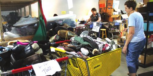 Above and below, volunteers at Second Chance Emporium have been working hard to process and sanitize the mountain of donations that have been coming in, but they can’t keep up – and even their new larger facility can’t hold them all. Photos by Jeff Wick