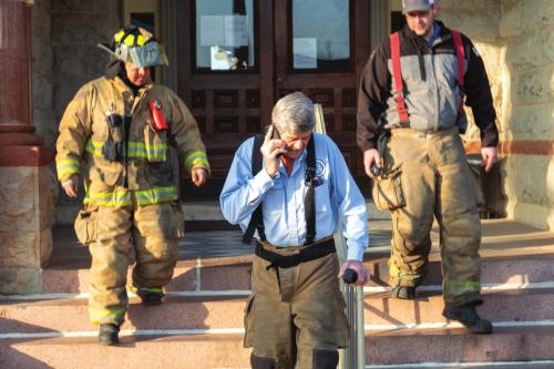 La Grange Assistant Fire Chief Frankie Srubar (center) leads a team of firefighters out of the courthouse Monday morning after checking for a gas leak. County leaders evacuated the courthouse that morning after noticing a strong smell of natural gas. The smell turned out to be associated with some work on a natural gas line at the new Business 71 river bridge. Photo by Andy Behlen