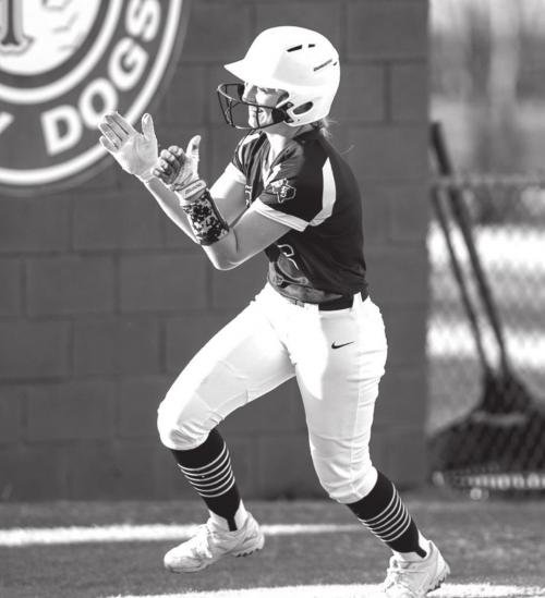 Abby Drabek celebrates her second homerun for the week as she rounds third heading to home plate where her team mates are gathered to greet her. Photo by Stephanie Steinhauser