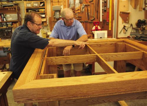 Father Eddie Winkler, left, chats with Bob Stanzel, right, as they examine the altar Stanzel is building for the new Hostyn Catholic Church. Photos by Jeff Wick