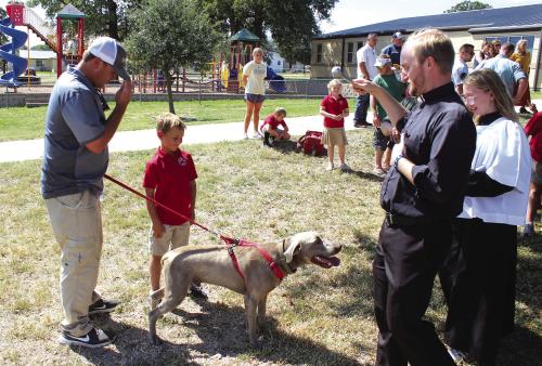 The lawn in front of Sacred Heart School in La Grange was a festive place Tuesday as students and their parents brought cats, dogs, a pony and at least one snake to the annual Blessing of the Pets ceremony in honor of the Feast Day of St. Francis of Assisi, the Patron Saint of Animals. After a short prayer service, Father Brian Phillips, above right, walked around to all the pets and sprinkled them with holy water. Some students even brought their stuffed animals for the event. Photo by Jeff Wick