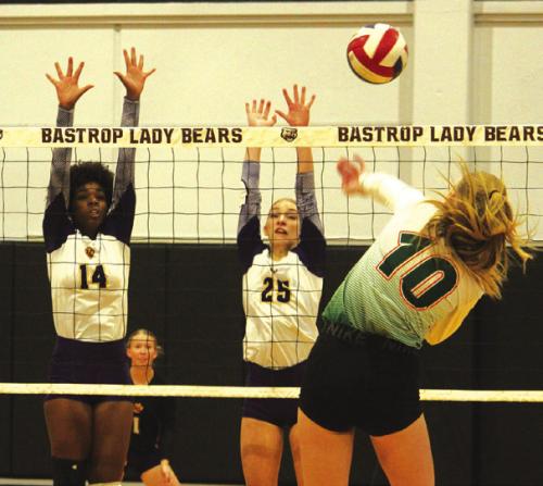 La Grange’s Tori Harold, left, and Kylie Trlicek, center, jump to block a hit by Gateway Prep’s Addie Brown. Photos by Jeff Wick