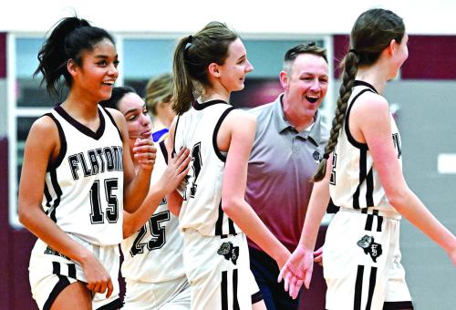 Coach Robert Gray and the Flatonia Lady Bulldogs celebrate with Summer Sodek after she nails a half-court three-point shot in Tuesday’s 47-40 win over the The Weimar Lady Wildcats. The Lady Bulldogs have defeated the Lady Wildcats twice this season. Photo by Stephanie Steinhauser