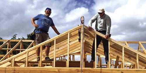 The vision of a warm and welcoming future is rapidly becoming reality for Johnny Wright, a devoted father to four children—Demarion (18), Billy (10), Sam (7), and Julie (5) who have partnered with Habitat for Humanity to build a better future. The family, currently living in a two-bedroom apartment, will soon move into the above spacious new home, with Habitat volunteers shown here, Executive Director Kenny Couch, left, and Norman Wied, right.