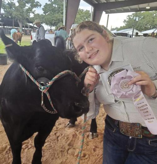 Rheagan Karisch is pictured here with one of her halter heifers at the Fayette County Junior Commercial Heifer Show.