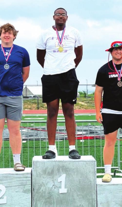 Jaren Woods atop the podium after winning the discus at area.