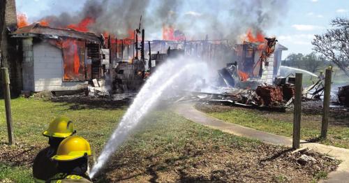 Ledbetter firefighters battle a house fire in April. The department celebrates this 75th anniversary this weekend. Record file photo