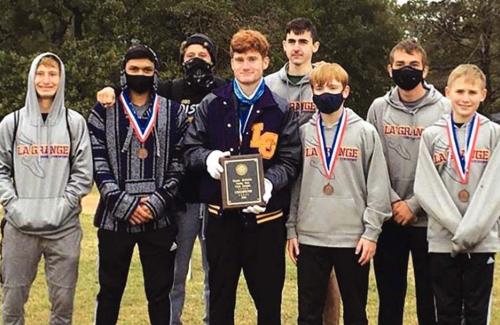 The La Grange boys cross country team holds up their district championship trophy.