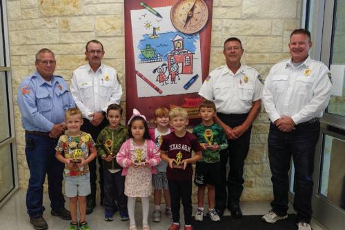 Fire poster winners and honorable mentions from Pre-K and kindergarten at La Grange Elementary went to (front, from left) Easton Roberts-Oppermann, Mireya Salinas, Truitt Ulrich, (middle) Lochlan Stewart, Jenna Long and Brooks Adamcik. They are pictured with (back) Kenneth Chovanec, Glen Knigge, Frank Menefee, and Todd Johnson of the La Grange Volunteer Fire Department. Photo by Andy Behlen