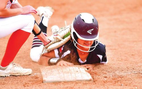 Flatonia’s Elzah Herrera, baserunner for Annie Charanza, dives back to first base after attempting to advance to second base in action between the Schulenburg Shorthorns and Flatonia Lady Bulldogs. Photo by Stephanie Steinhauser
