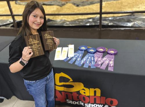 Elyse McBroom pictured with all of her awards from the San Antonio Stock Show and Rodeo Photography Contest.