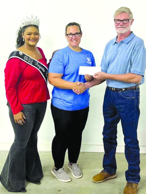 Fayette County Fair Queen Harper Henneke represented the La Grange Optimist Club who received a donation of $2,964.50. Pictured from left: Harper Henneke, Optimist representative Misty Rox and Fair President Mike Zuhn.