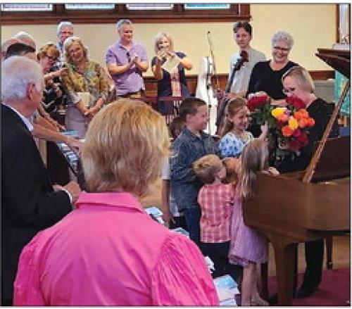 Mary Ann Hatfield’s grandchildren present her flowers after the concert.
