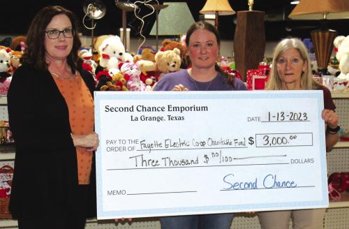 Fayette Electric Cooperative Marketing and Training Coordinator Tracy Denton accepts a grant from Second Chance Emporium representatives Stacy Cada and Gayle Schielack.