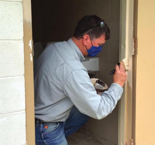 An LCRA employee paints a restroom at Northside Park in La Grange during LCRA’s Steps Forward Day on April 9. During the annual day of service, employees worked on more than 30 community projects.