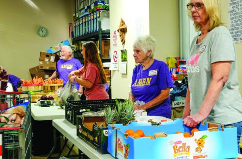 Volunteers at the AMEN Food Pantry in La Grange stand ready to distribute food Monday. The pantry served many more folks than usual. Photo by Andy Behlen