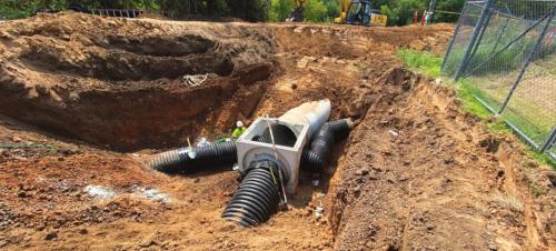 School drainage piping junction box north of river discharge headwell.
