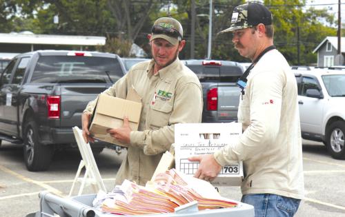 FEC Lineman Corey Brown and lineman apprentice Justin Neiser prepare documents for shredding at last year’s Community Shred Day.