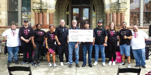 T-Mobile presented the Fayette County Fair Association with a $50,000 Hometown Grant on Thursday, July 17, in a ceremony in front of the Courthouse. Pictured hold the check in the center are Fair Association President Michael Zuhn (left) and T-Mobile Market Manager Rick Molina (right), along with a delegation of representatives from T-Mobile. Photo by Andy Behlen