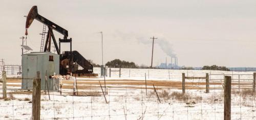 A pump jack on East Radhost School Road stood idle last Tuesday as a plume of steam rises from the Fayette Power Project in the background.
