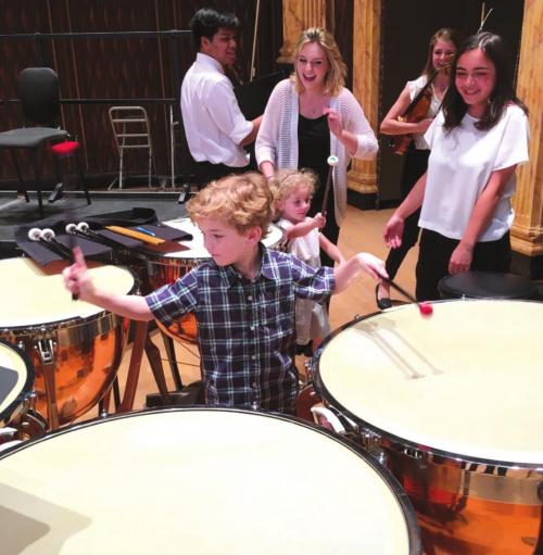 Festival Hill orchestra members encourage a future timpanist during annual Young Persons Concert.