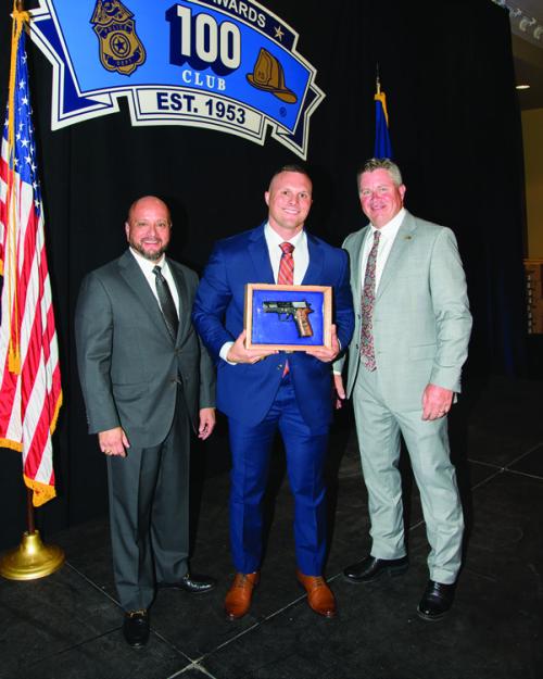 100 Club President Ray Garcia (left) and Executive Director William Skeen (right) presented La Grange Police Officer Mitchell Maxwell with an Officer of the Year award at the 100 Club’s annual banquet on May 22. Maxwell (center) is pictured with a commemorative pistol that came with the award.