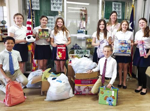 During Catholic Schools Week, students perform community service. St. Michael Catholic School in Weimar was visited by Kristi Bauer from CASA of Bastrop, Fayette &amp; Lee Counties to talk about children in need. St. Michael students collected games, toys, diapers, and other needed items. Pictured are (front, from left) Chandler Williams and Cade Wessels, (back) Andie Melnar, Sarah Jane Berger, Kendall Jahn, Ella Herzik, CASA Executive Director, Kristi Bauer, Olivia Elstner, and Emily Wied.
