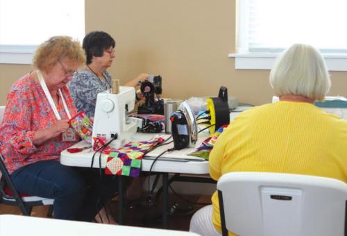 Above and below: Colorado Valley Quilt Guild members at work creating quilts to be donated to local nursing homes.