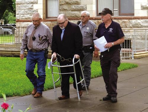 Jackie Wotipka, 53, (second from left) is walked out of the Fayette County Courthouse by officers after his sentencing Thursday. Photo by Andy Behlen